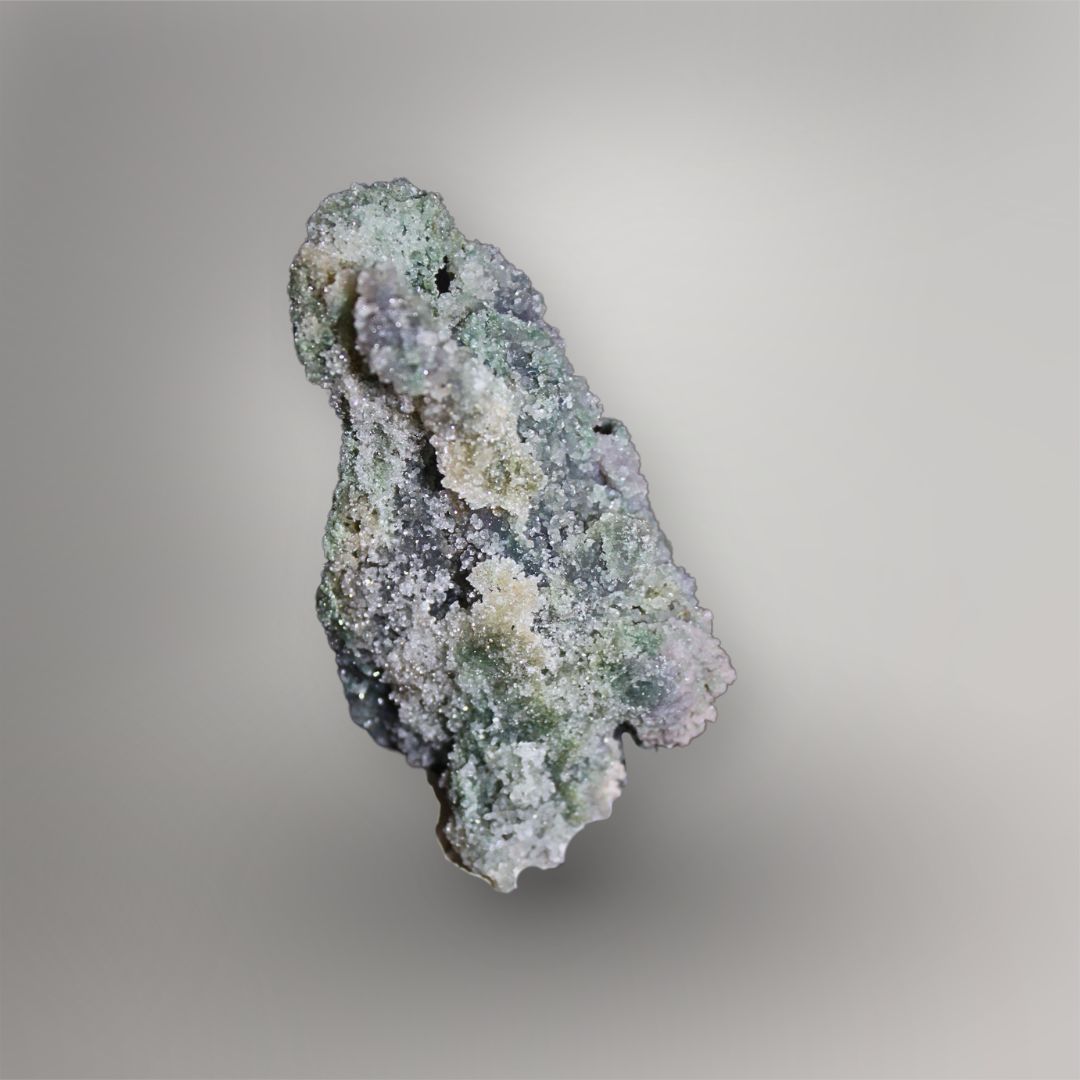 Side view of 259g Grape Agate cluster showing recessed channels, layered quartz growth, and pale green mineral texture
