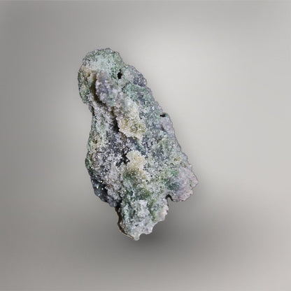 Side view of 259g Grape Agate cluster showing recessed channels, layered quartz growth, and pale green mineral texture