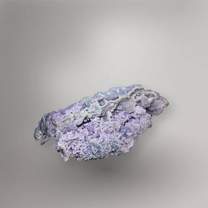 Reverse of 335g Indonesian Grape Agate cluster showing pale lavender quartz, layered pocket walls, and recessed cavities