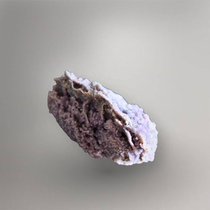 Side view of 335g Grape Agate cluster showing overlapping mineral layers, open pockets, and pale lavender quartz growth
