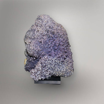 Front view of 770g lavender Grape Agate cluster from Indonesia mounted on a black display base