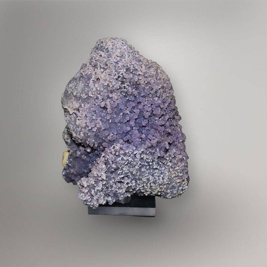 Front view of 770g lavender Grape Agate cluster from Indonesia mounted on a black display base