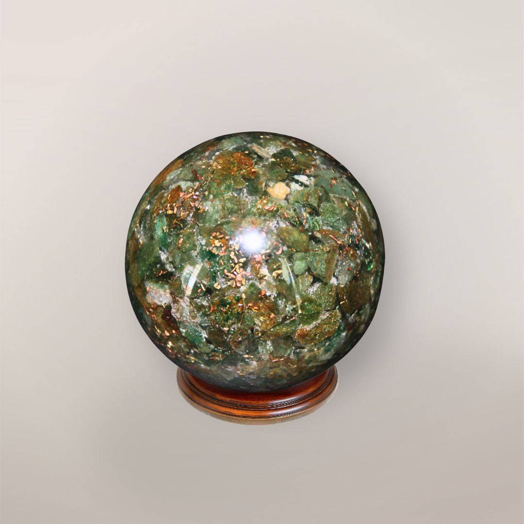 Back view of handmade Green Aventurine orgonite sphere showing natural green stone chips, copper flakes, and resin texture