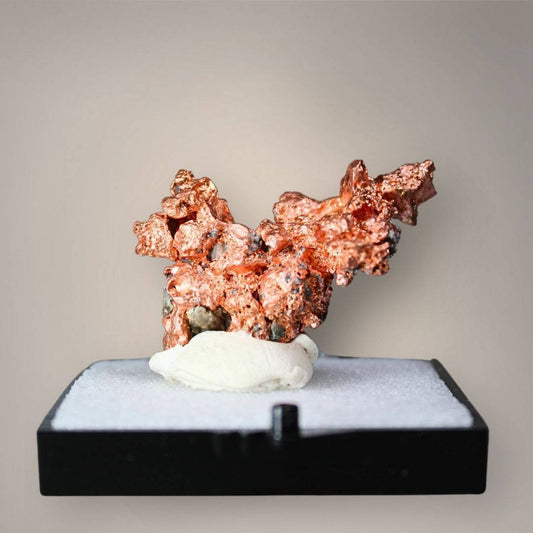 Native copper specimen from China with compact branching growth, angular metallic projections, and copper-red crystalline surfaces displayed on a black perky base.