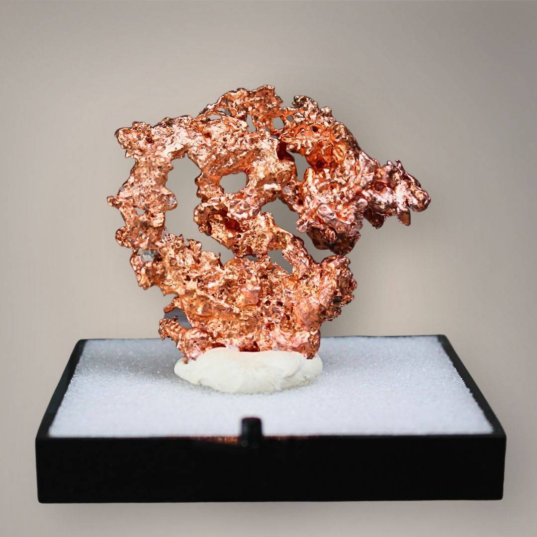 Front view of Chinese native copper featuring an irregular circular openwork formation, branching metallic growth, and textured copper-red surfaces on a black perky base.