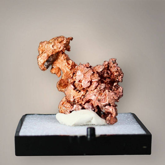 Native copper specimen from China featuring clustered copper-red crystalline growth, irregular branching projections, and textured metallic surfaces displayed on a black perky base.