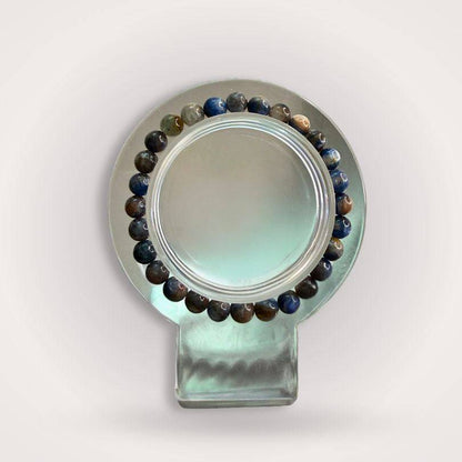 Blue Kyanite Beaded Bracelet with 6mm polished stones displayed on a round stand, ideal for promoting calm focus and alignment.