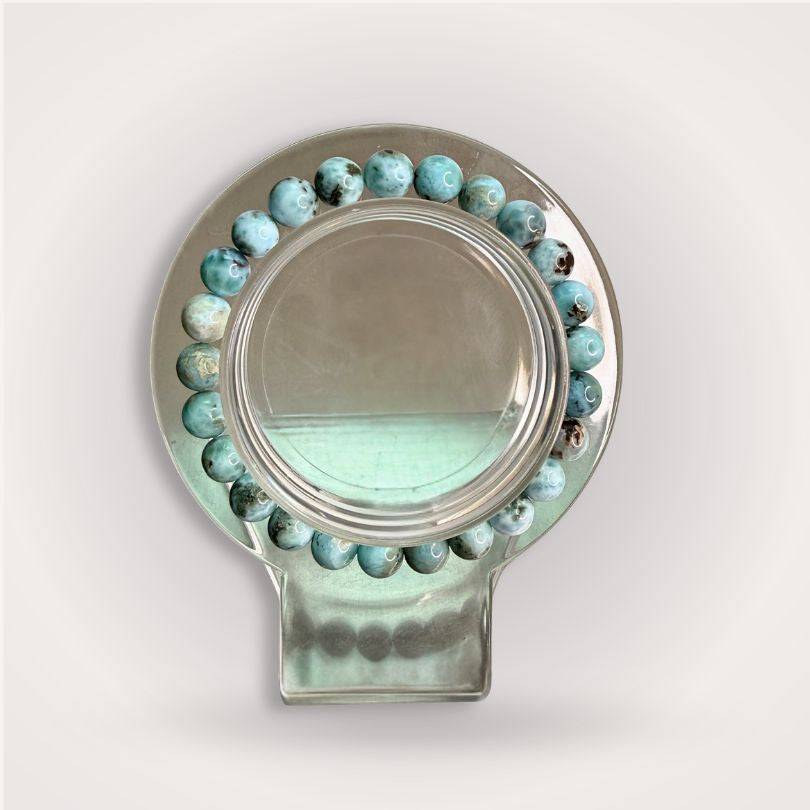Larimar Beaded Bracelet - 7mm displayed in a circular holder, showcasing soothing blue tones and polished finish for calming energy and communication.