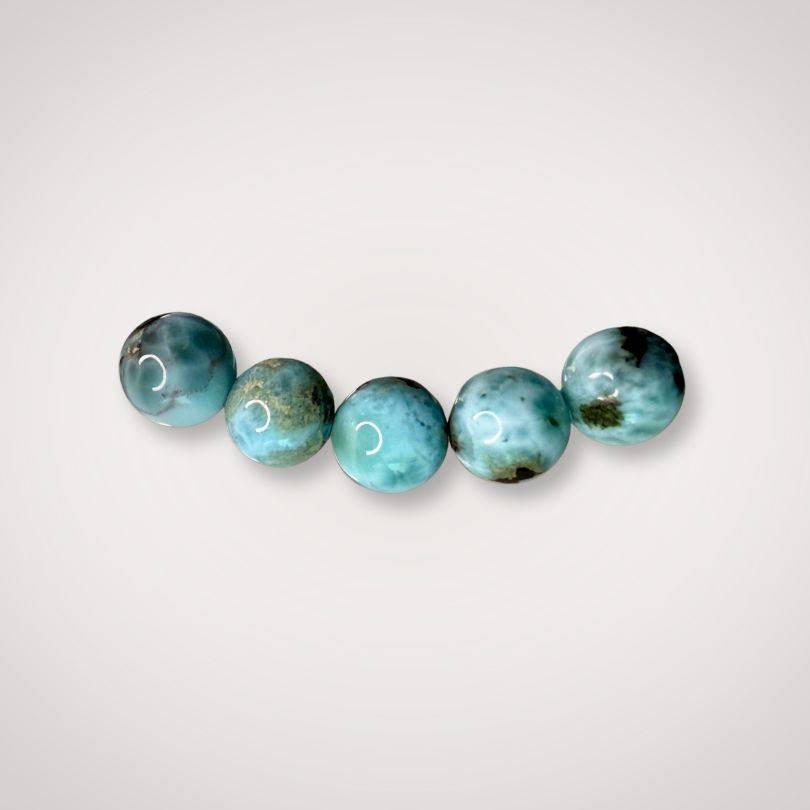 Close-up of five 7mm Larimar beads with natural blue and white marbling, emphasizing the bracelet’s serene energy and Dominican origin.