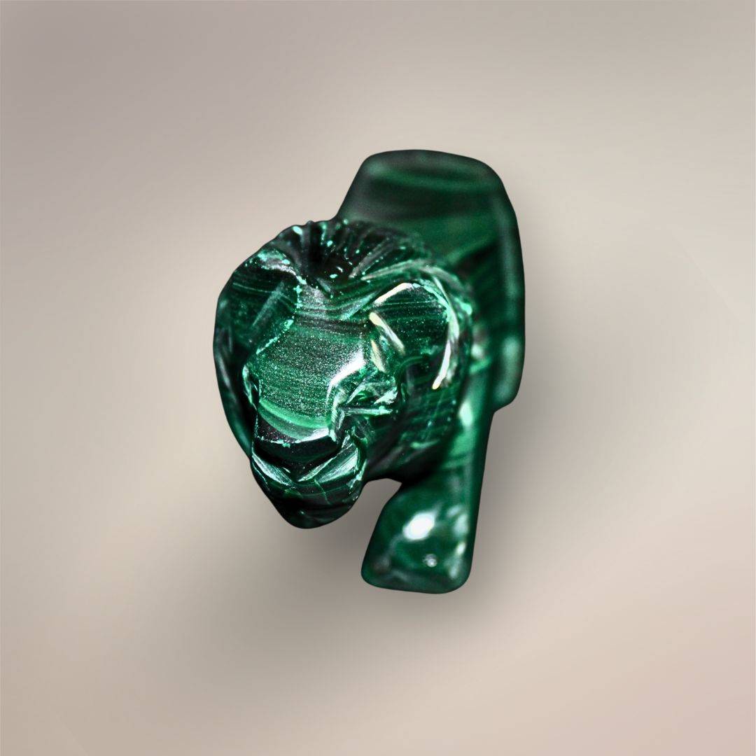 Front view of the Malachite lion carving with a defined face, carved mane, front legs, and dark green polished finish.
