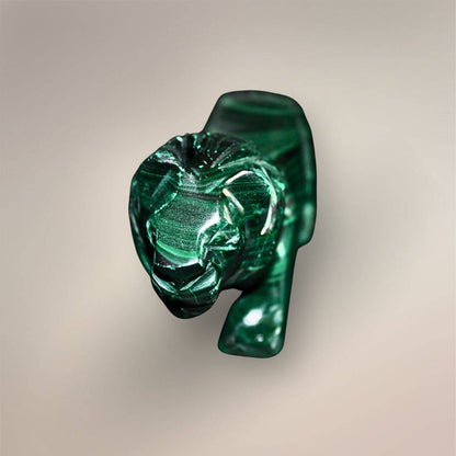 Front view of the Malachite lion carving with a defined face, carved mane, front legs, and dark green polished finish.