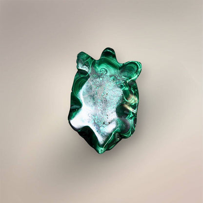 Bottom view of a Malachite turtle carving showing the flat polished underside, carved head and limbs, and natural green patterning.