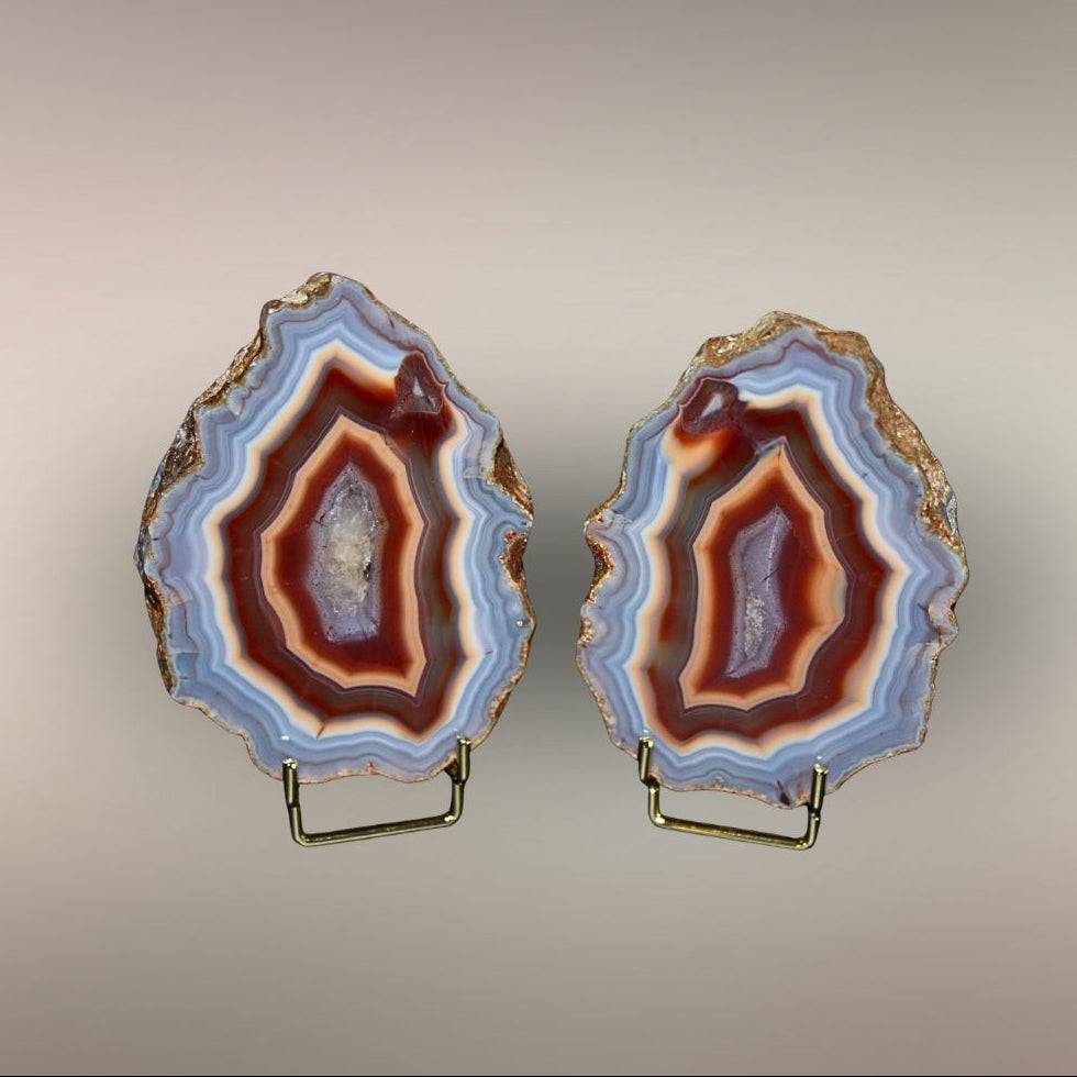 Upright view of Ngabu Malawi Agate pair showing polished faces, natural rind, and warm banded centers.