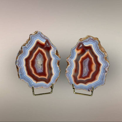 Upright view of Ngabu Malawi Agate pair showing polished faces, natural rind, and warm banded centers.