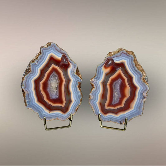 Upright view of Ngabu Malawi Agate pair showing polished faces, natural rind, and warm banded centers.