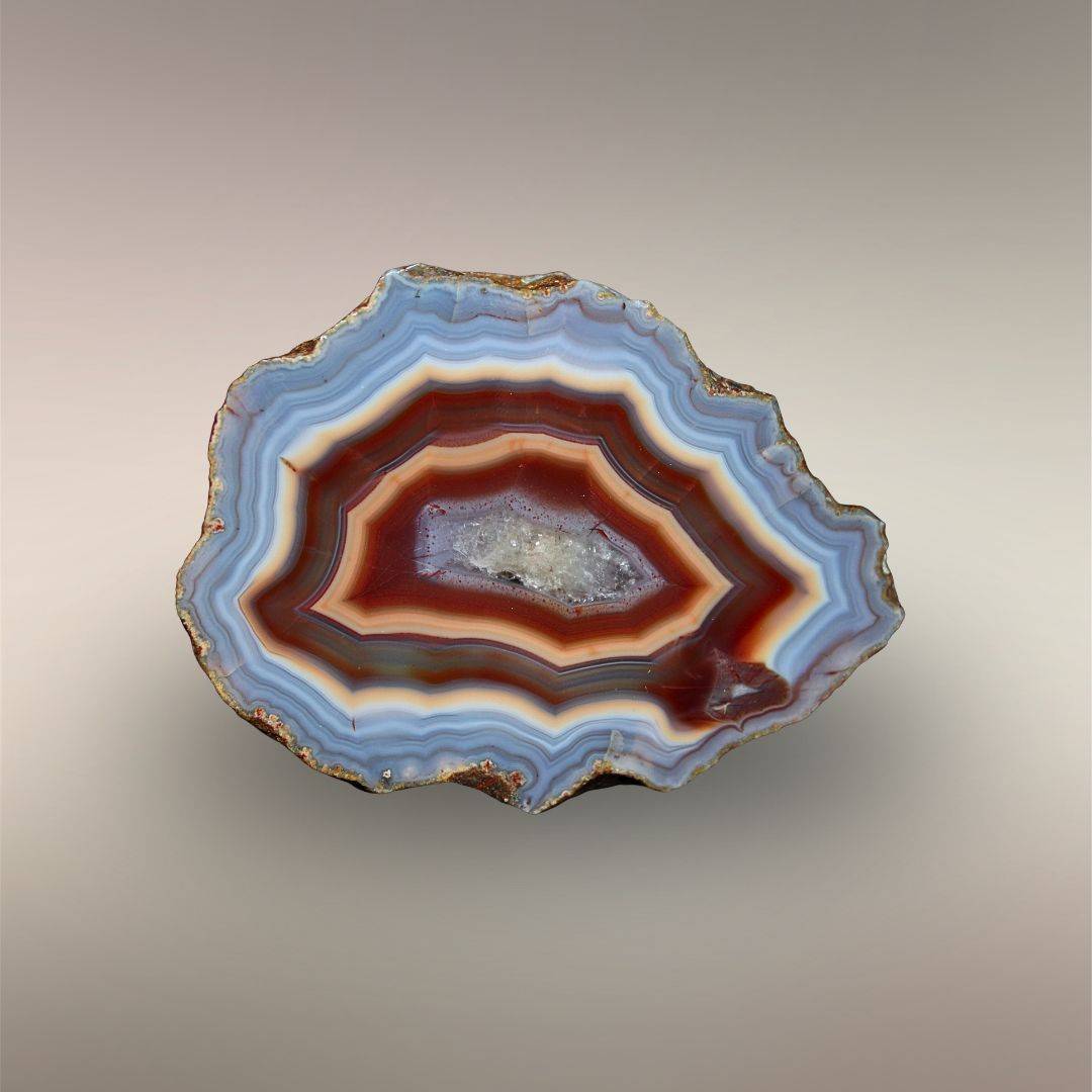 Single half of Ngabu Malawi Agate nodule pair with blue-gray outer banding and amber-red central zoning.