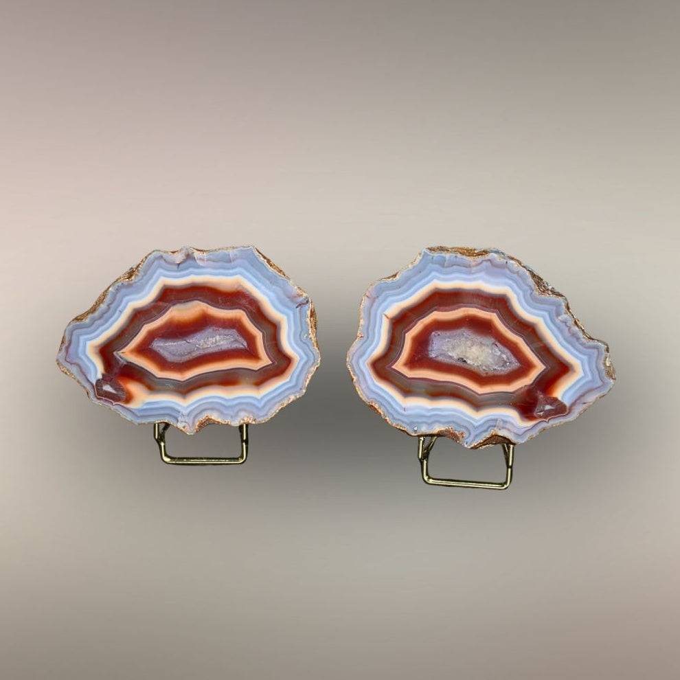 Ngabu Malawi Agate matched nodule pair with multi-color banding and quartz centers displayed on stands.