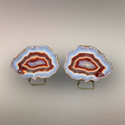 Ngabu Malawi Agate matched nodule pair with multi-color banding and quartz centers displayed on stands.