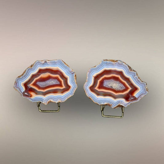 Ngabu Malawi Agate matched nodule pair with multi-color banding and quartz centers displayed on stands.