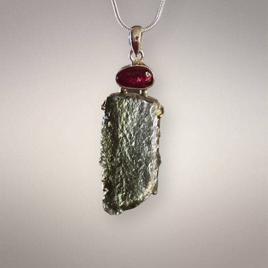 Front view of Angel Chime Moldavite pendant with an elongated olive-green textured form and deep pink-red oval rubellite cabochon.
