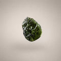 Close-up of Czech Republic Moldavite with olive-green translucence, rounded ridges, grooves, and a naturally sculpted glass surface.