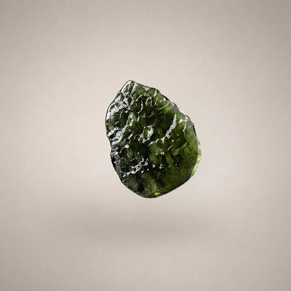 Close-up of Czech Republic Moldavite with olive-green translucence, rounded ridges, grooves, and a naturally sculpted glass surface.
