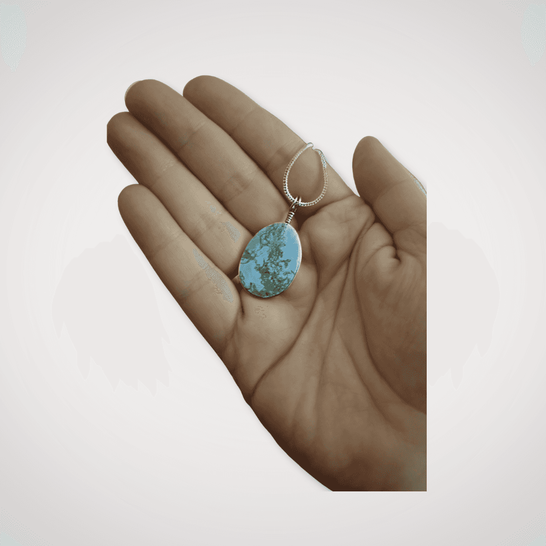 Hand holding Indonesian Blue Opal pendant with silver chain
