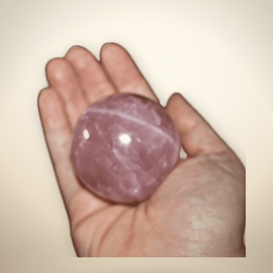 Rose Quartz 55mm sphere held in hand for emotional healing
