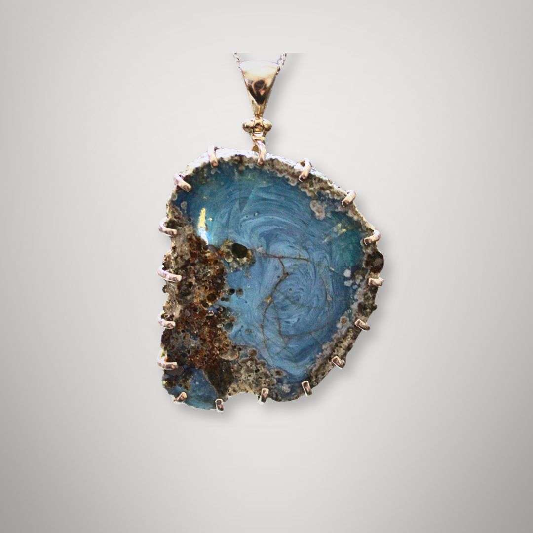 Close-up of Swedish slag glass pendant with vortex pattern and sterling silver setting