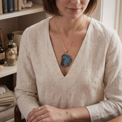 Model wearing Swedish slag glass pendant with vortex pattern on silver chain