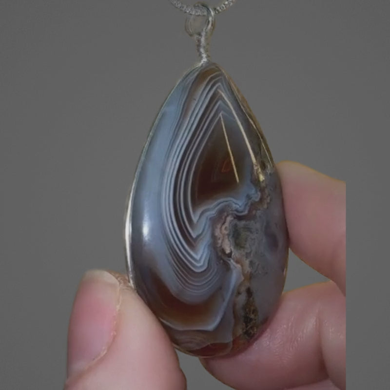 Close-up of Botswana Agate pendant showing parallax ghost effect and polished finish