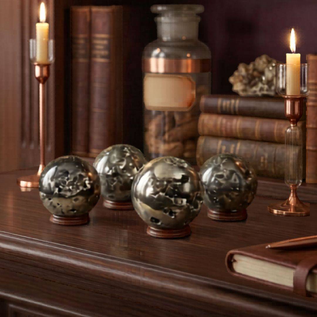Group of Peruvian Pyrite geode spheres displayed on a wooden desk with candles, antique books, and warm apothecary styling.