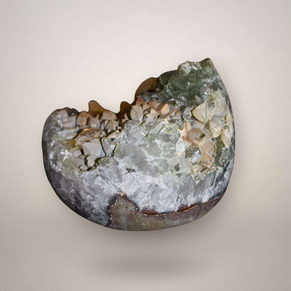 Angled view of quartz geode interior showing calcite crystal layering and green chlorite quartz formation