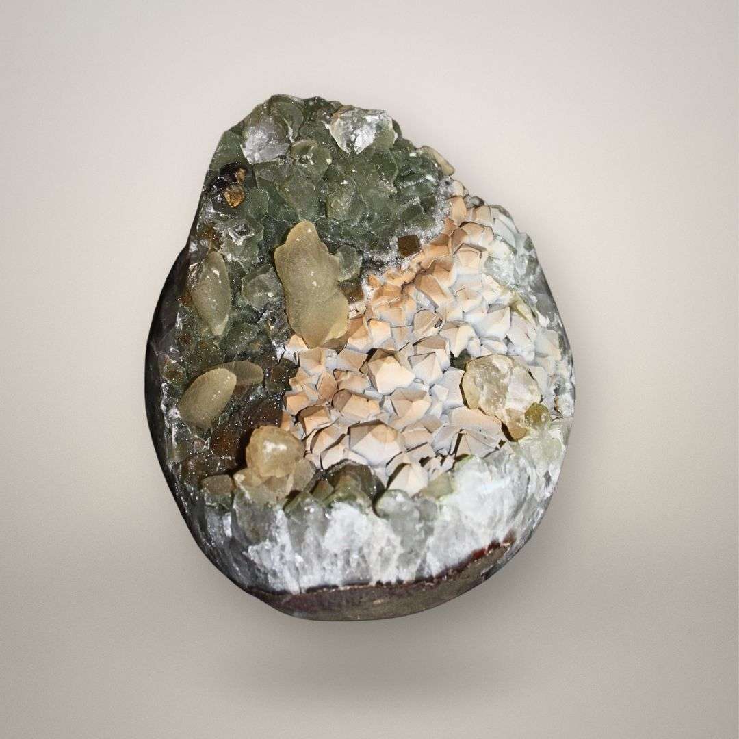 Brazilian quartz geode with chlorite-included green quartz and cream calcite crystals, front view showing open cavity structure