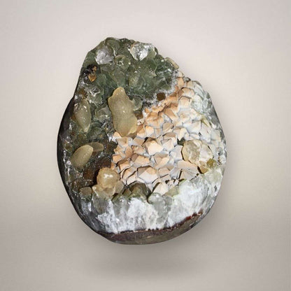 Brazilian quartz geode with chlorite-included green quartz and cream calcite crystals, front view showing open cavity structure