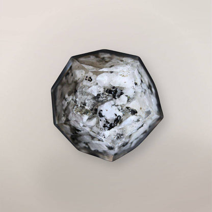 Back view of handmade Rainbow Moonstone orgonite dodecahedron showing white stone chips, dark inclusions, metallic flakes, and faceted resin texture