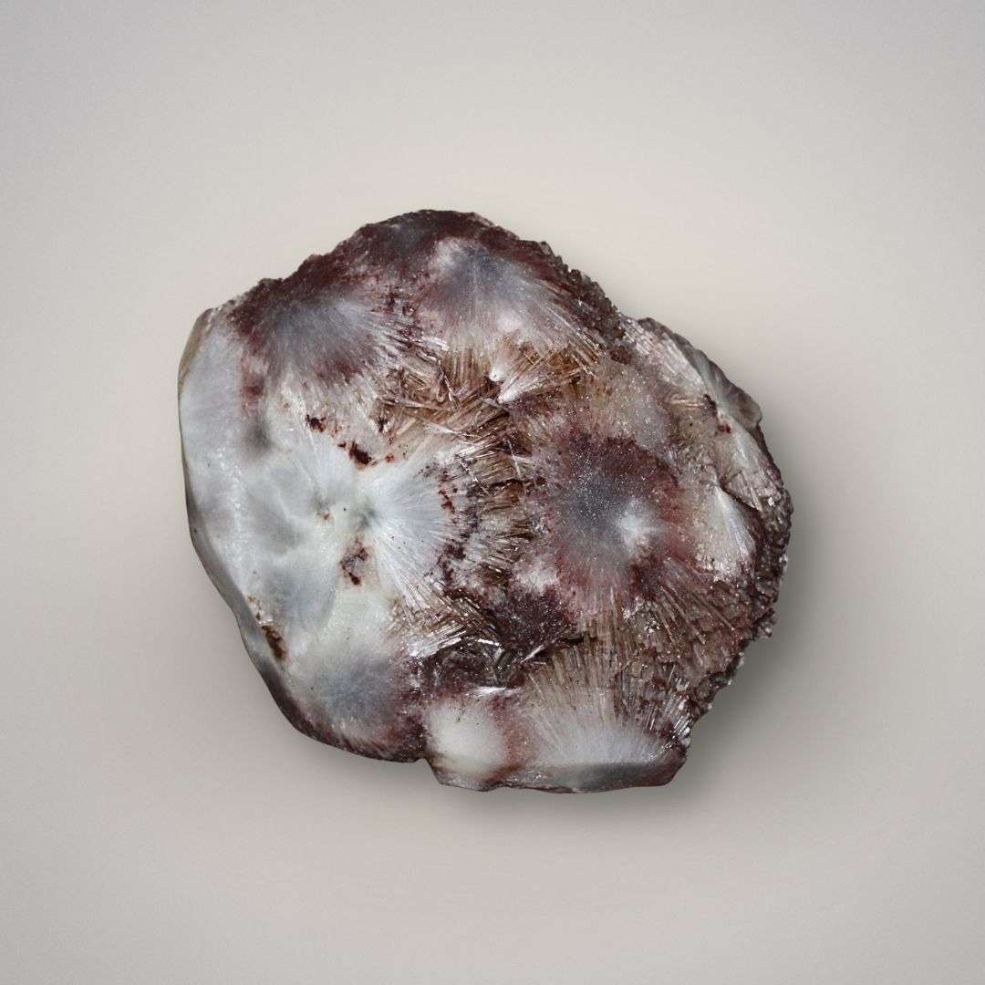 Back view of red scolecite mineral specimen showing white fibrous sprays, hematite-rich red coloration, and natural zeolite crystal growth