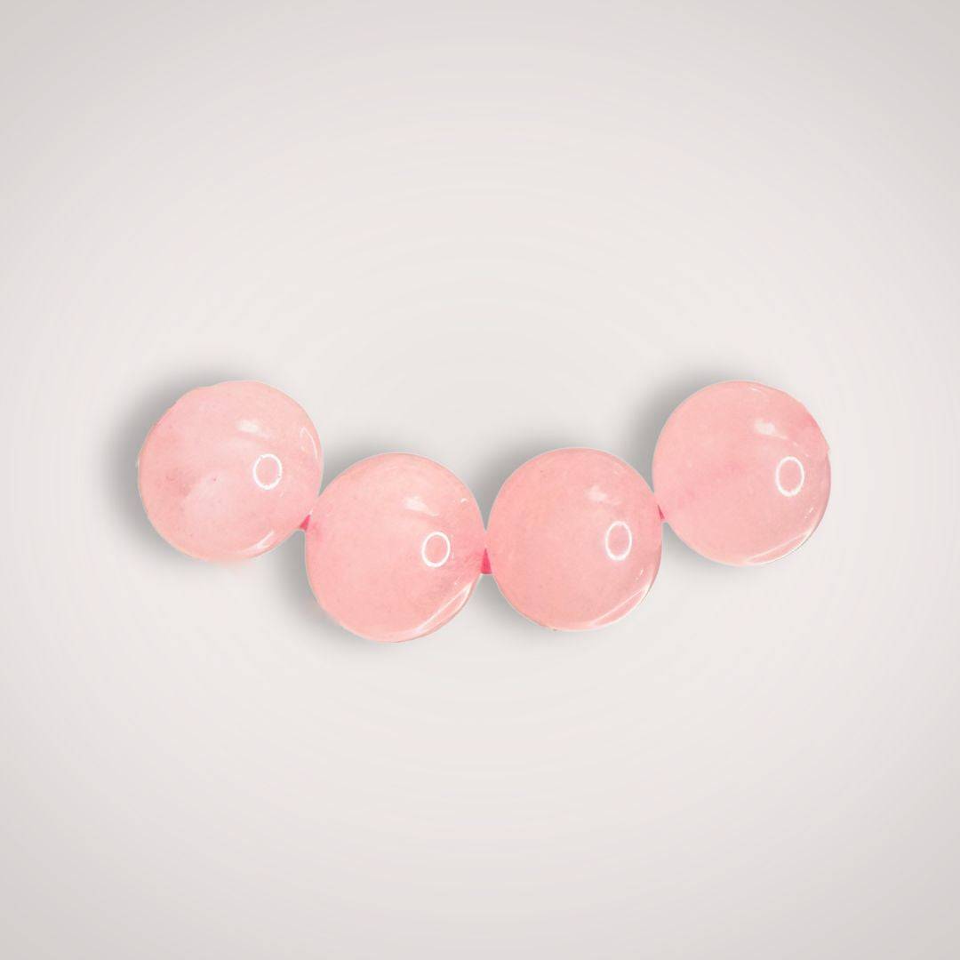 Close-up of three 8mm Rose Quartz beads, emphasizing their smooth finish and gentle pink tone ideal for emotional healing jewelry.