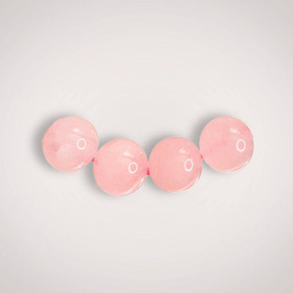 Close-up of three 8mm Rose Quartz beads, emphasizing their smooth finish and gentle pink tone ideal for emotional healing jewelry.