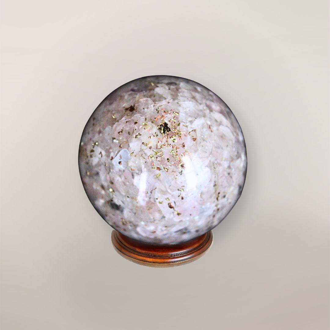 Back view of handmade Rose Quartz orgonite sphere showing pale pink stone chips, copper flakes, and resin texture