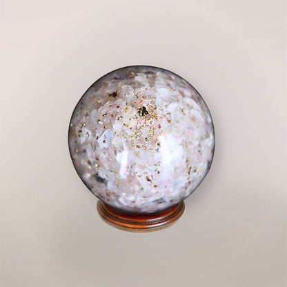 Back view of handmade Rose Quartz orgonite sphere showing pale pink stone chips, copper flakes, and resin texture