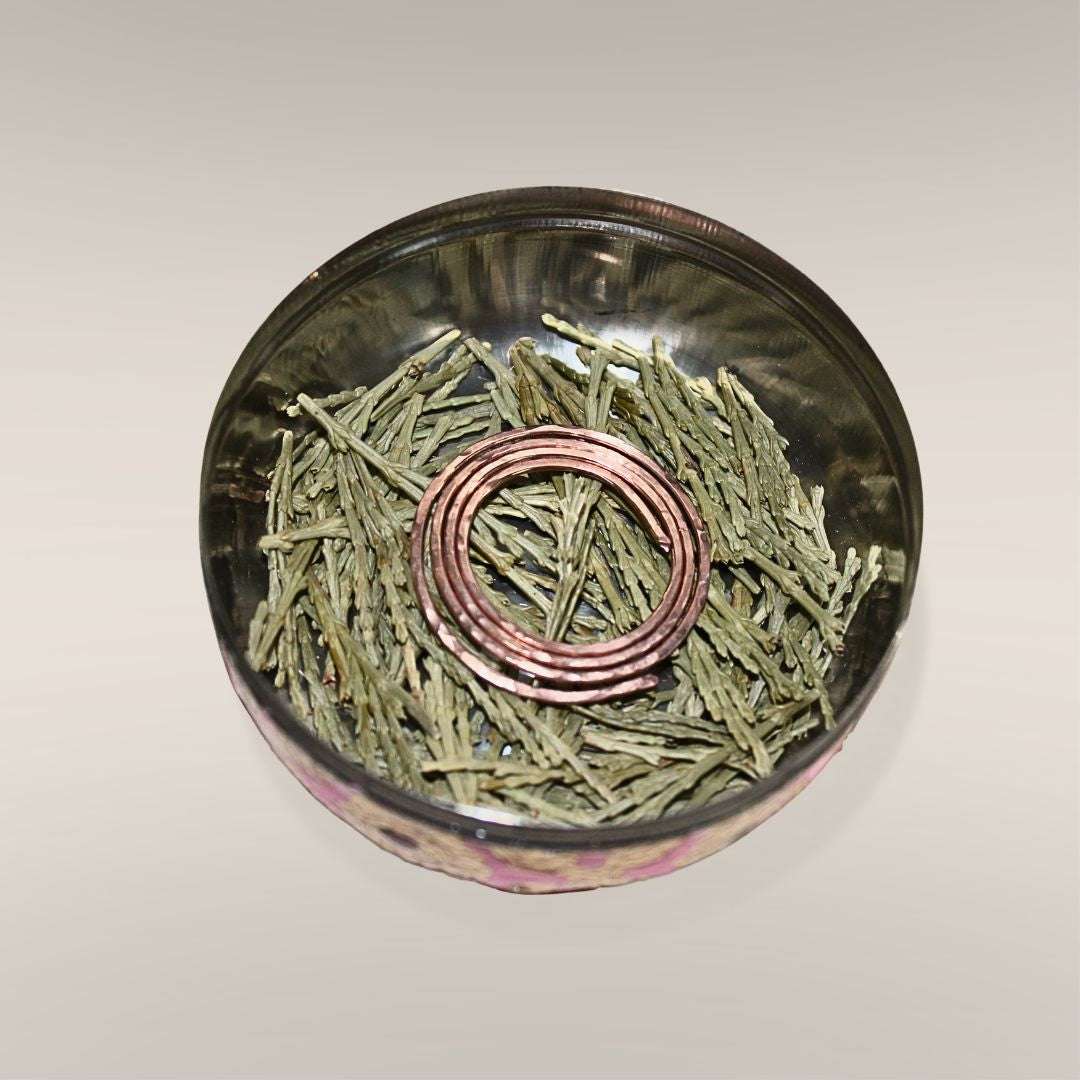 Inside the Safe Travels Ritual Box showing loose Mt. Shasta cedar and a hand-formed copper spiral at the base of the box
