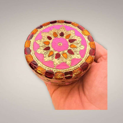 Safe Travels Ritual Box shown in hand for scale, featuring a round pink and gold mandala lid
