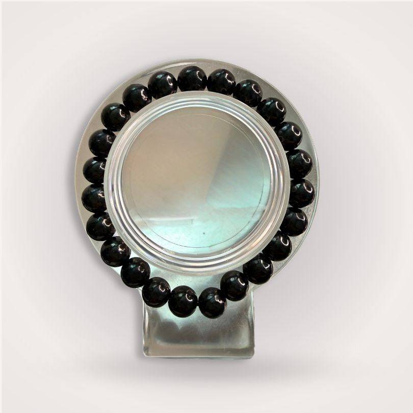 Shungite Beaded Bracelet 8mm displayed in a circular arrangement on a clear stand, showcasing its glossy black beads for grounding and protection.