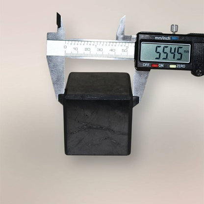 Shungite cube measured with digital calipers showing approximately 55.45mm width against a neutral background