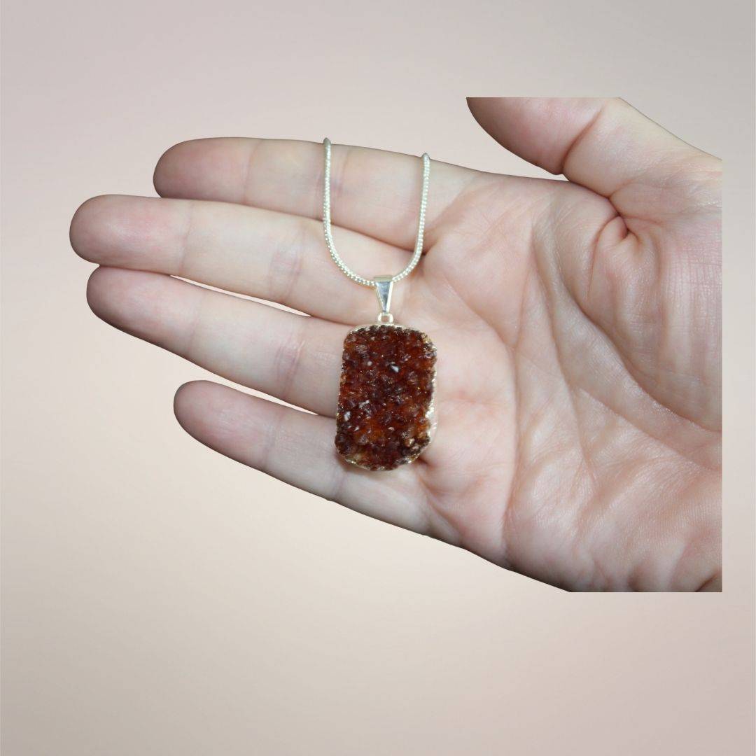 Smoky citrine cluster pendant held in hand showing approximate 40 by 30 mm size and natural crystal texture