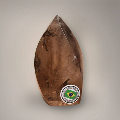 Reverse view of Brazilian Smoky Quartz Flame showing internal inclusions, polished contours, and a Made in Brazil sticker.