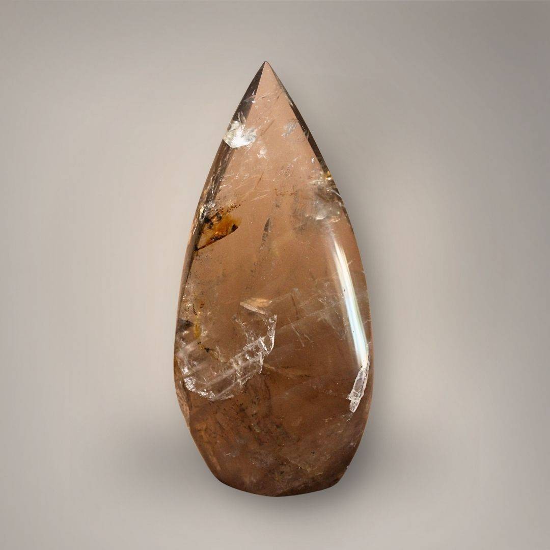 Front view of Madagascar Smoky Quartz flame with translucent brown quartz, golden-healer area, internal veils, and polished pointed form.