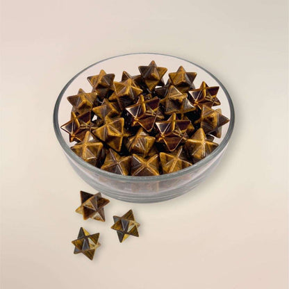 Tigers Eye Merkaba star-shaped gemstone in a glass bowl