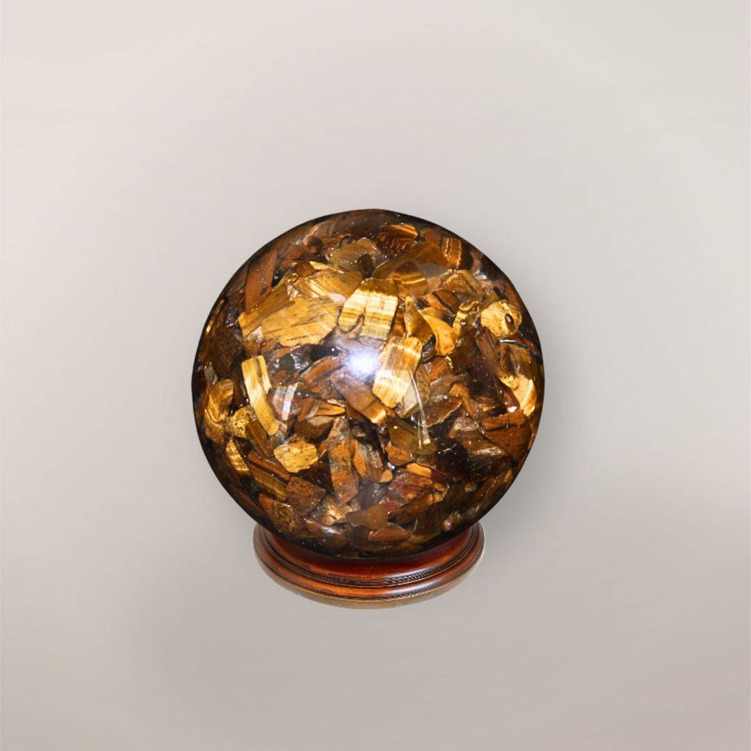 Back view of handmade Tiger’s Eye orgonite sphere showing natural stone chips, copper flakes, and resin texture